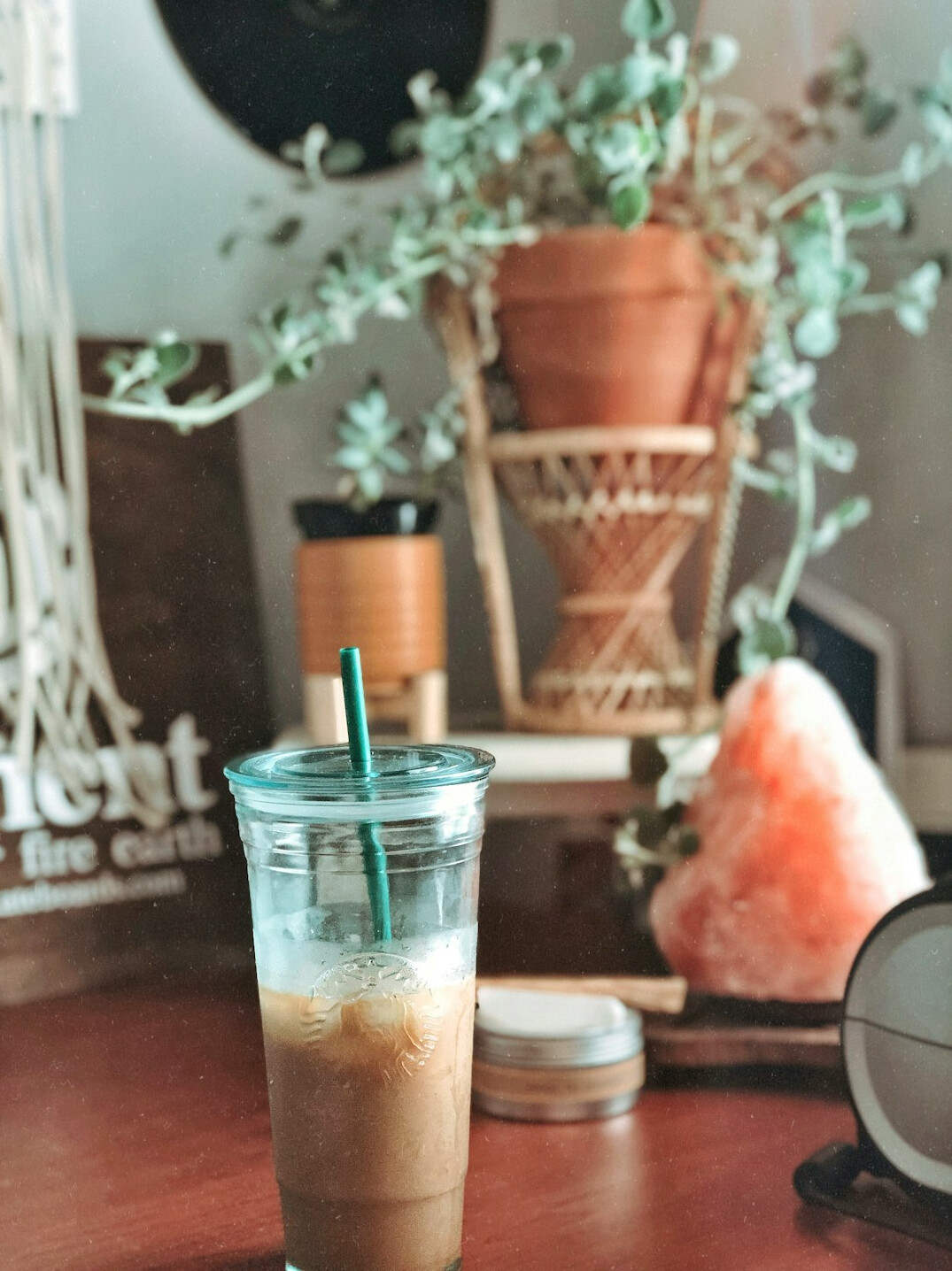 Coffee mug, plant and notebook on a tidy desk by a window